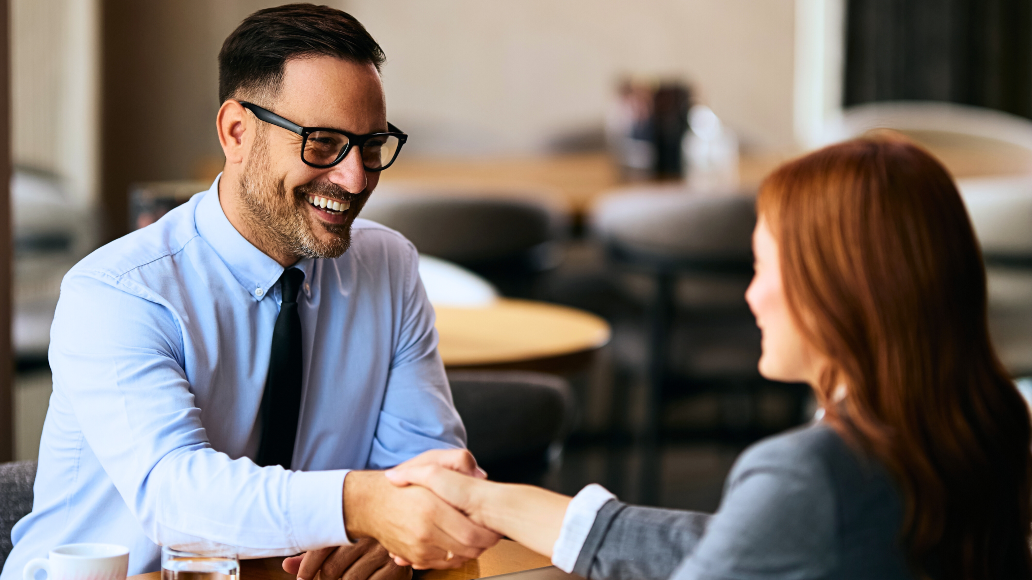 Service Excellence - 5* Sterne Kundenerlebnis - Berater schüttelt Kunden lächelnd die Hand
